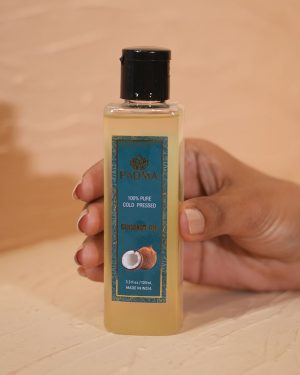 Hand holding bottle of 100% pure cold-pressed coconut oil image on padma home page