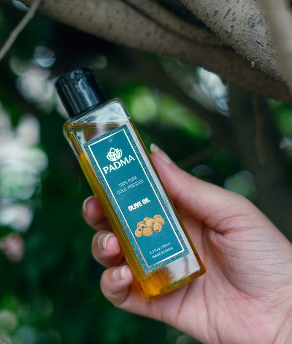 Hand holding bottle of 100% pure cold-pressed olive oil image on padma home page