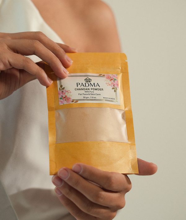 Hand holding Padma Chandan Powder for face and skin image on padma home page