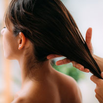 Applying hair conditioning product to long, dark hair image on padma home page
