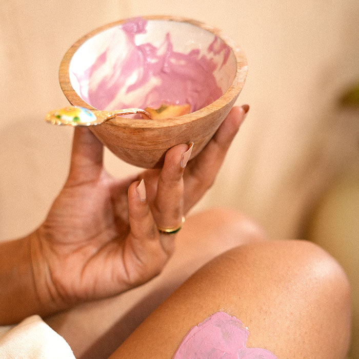 Hand holding bowl with pink skincare product image on padma gallery page