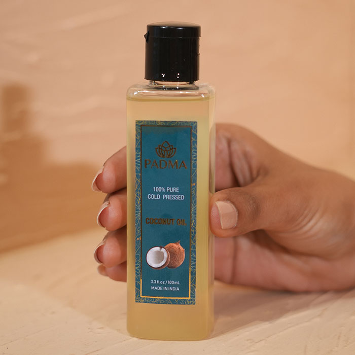 Hand holding bottle of 100% pure coconut oil image on padma gallery page